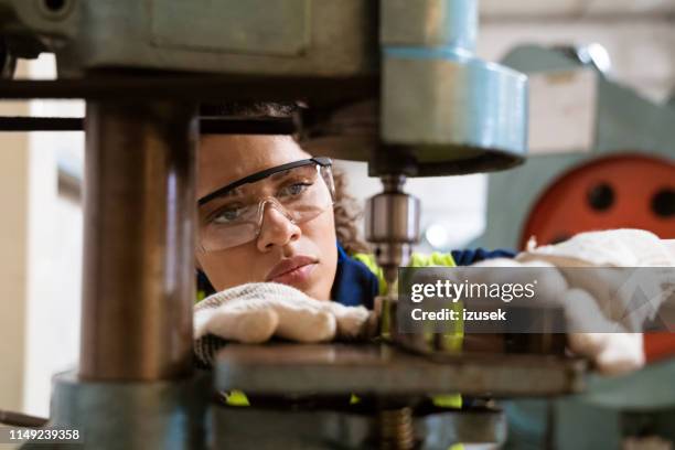 lehrling mit joke-maschine in der fabrik - safety glasses stock-fotos und bilder