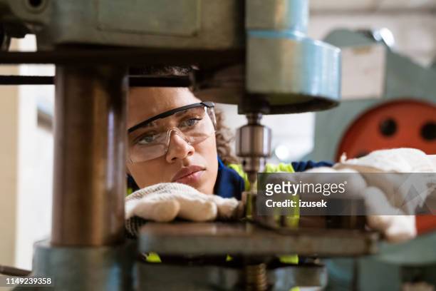 vrouwelijke leerling met juk machine in de fabriek - beroep stockfoto's en -beelden