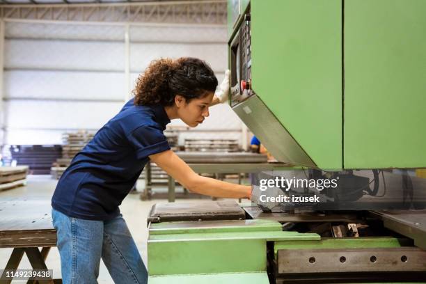 ingenieurin mit pullermaschine in der fabrik - metallhandwerk stock-fotos und bilder