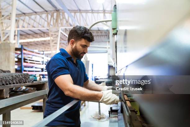 ingegnere maschio che utilizza macchina estratrice in fabbrica - operaio metallurgico foto e immagini stock