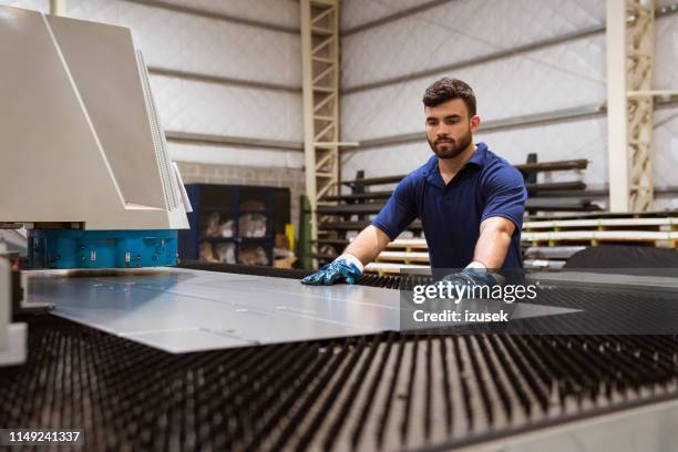 serious engineer adjusting metal on puller machine - sheet metal stock pictures, royalty-free photos & images