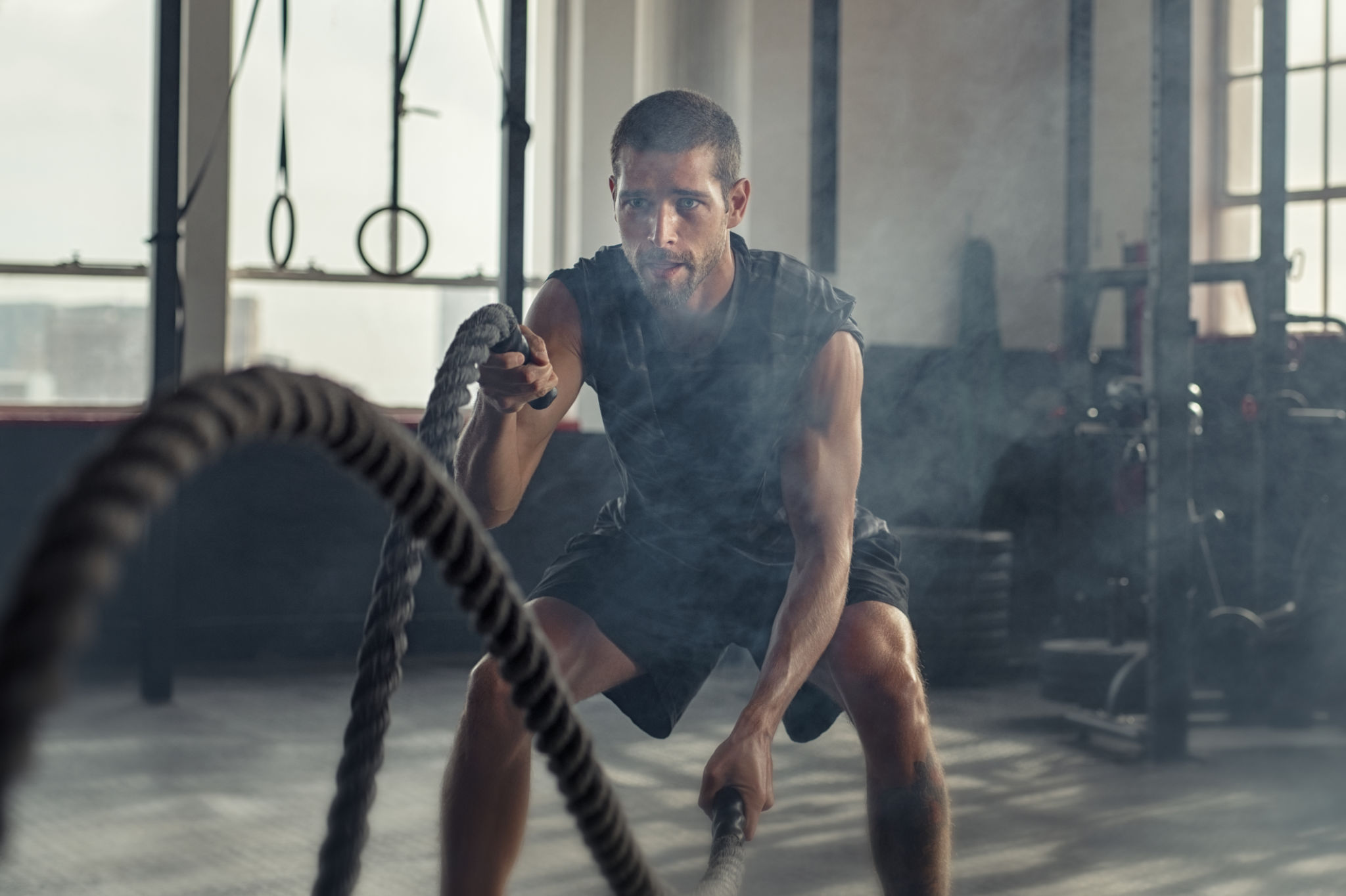 Young man exercising using battle rope Young man exercising using battle rope