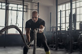 Mature strong man battling with rope