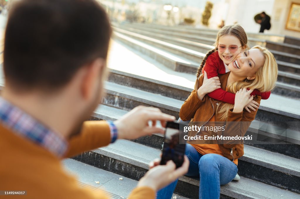 Father photographing his family outdoors