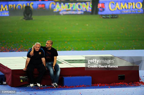 Head coach Josep Guardiola of FC Barcelona and delegate Carles Nadal of FC Barcelona sit on an empty podium during the celebrations after winning the...