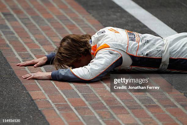 Dan Wheldon of England, driver of the William Rast-Curb/Big Machine Dallara Honda, kisses the bricks at the start/finish line after winning the IZOD...