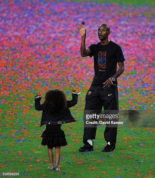 Eric Abidal of FC Barcelona and one of his daughters stand on the pitch during the celebrations after winning the UEFA Champions League Final against...