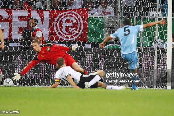 Walter Gargano of Uruguay scores his team's first goal against Philipp Lahm and goalkeeper Manuel Neuer of Germany during the international friendly...
