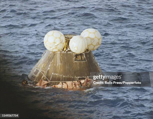 View of United States Navy frogmen from USS Iwo Jima in the water surrounding the Apollo 13 Command Module capsule containing the astronauts,...