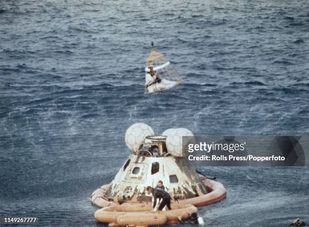 View of United States Navy frogmen from USS Iwo Jima standing on an inflatable surrounding the Apollo 13 Command Module capsule as Command Module...