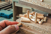 Furniture fittings, wooden dowels, fastener connection on chipboard workpieces, close-up