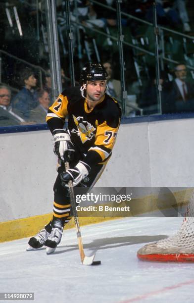 Paul Coffey of the Pittsburgh Penguins skates with the puck around the net during an NHL game circa 1990.