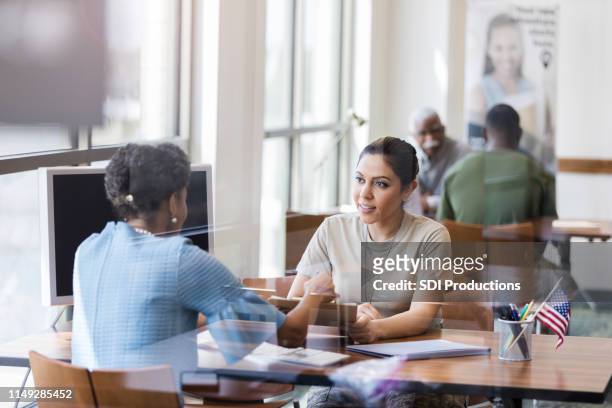 african american banker and hispanic soldier confer - banking stock pictures, royalty-free photos & images