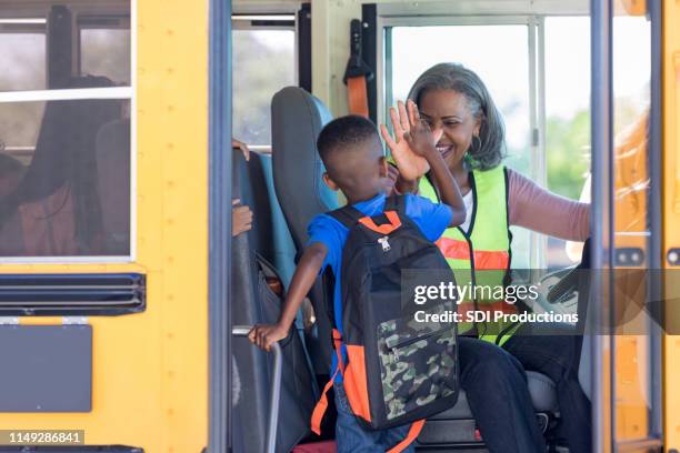 conductor de autobús alta cinco nuevos estudiantes de paso en autobús - school bus fotografías e imágenes de stock
