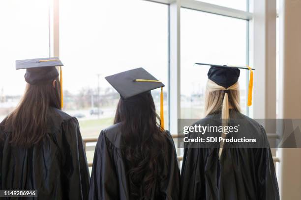 drie onherkenbare afgestudeerden wachten geduldig - back of womens heads stockfoto's en -beelden