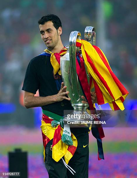 Barcelona's Sergio Busquets holds the Champions League trophy during a gathering with supporters at the Camp Nou stadium in Barcelona on May 29, 2011...