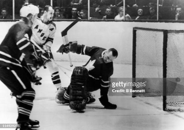 Goalie Johnny Bower of the Toronto Maple Leafs is scored on by Jean Ratelle of the New York Rangers as Don Marshall of the Rangers and Red Kelly of...