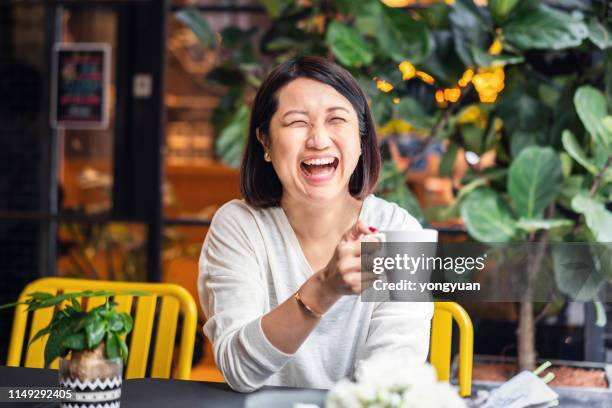 lachende chinesin in einem café - mature cafe happy stock-fotos und bilder