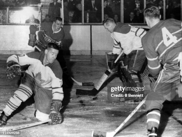 Goalie Johnny Bower and Tim Horton of the Toronto Maple Leafs try to block the puck as Jean Beliveau and Gilles Tremblay of the Montreal Canadiens...