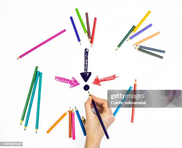 hand drawing arrows to a point with coloring pencils on white page - colored pencil arrow stock pictures, royalty-free photos & images