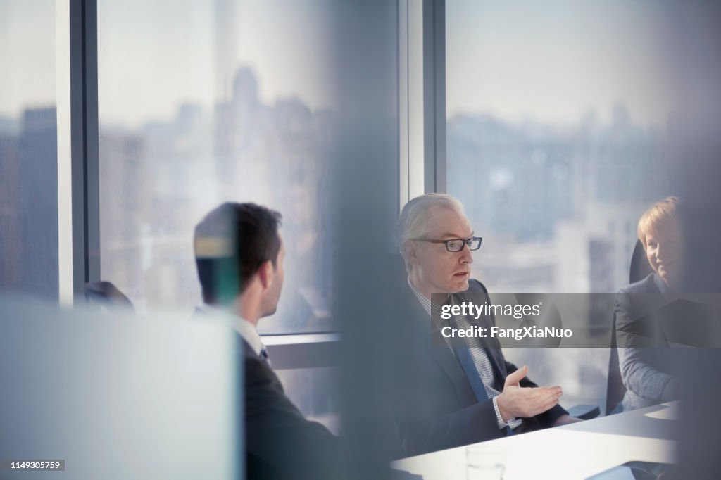 Durch den gläsernen Blick des Geschäftsmannes im Gespräch mit Kollegen in Konferenzzimmertreffen