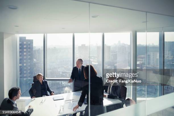 colleghi di lavoro che parlano in sala riunioni - chief executive officer foto e immagini stock