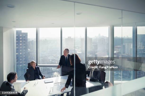 business colleagues talking in meeting room - executive management stock pictures, royalty-free photos & images