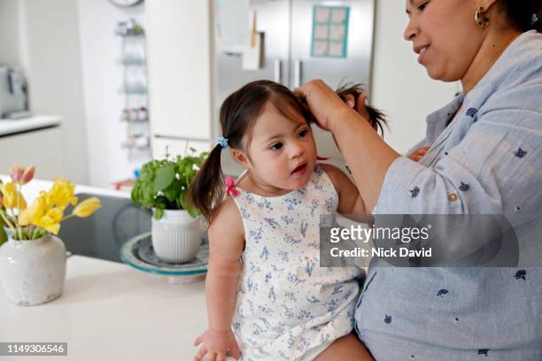 Mother doing pigtails in her daughter's hair