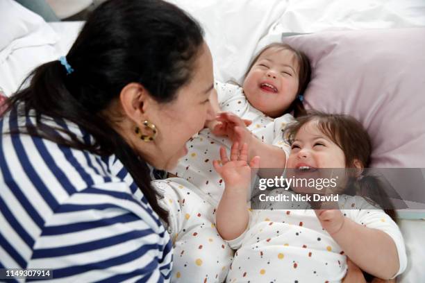 Candid portrait of mother tickling twin girls