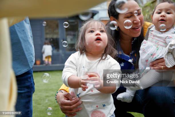 Mother watching children play with bubbles