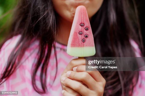 closeup young woman eating a watermelon ice  lolly - look stock-fotos und bilder