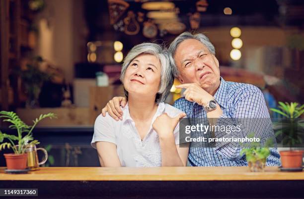 aziatisch paar zit in een cafe en de schuld te geven elkaar/joking en het maken van plezier/ - asian couple arguing stockfoto's en -beelden