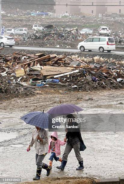 People walk in the rain on May 29, 2011 in Minamisanriku, Miyagi, Japan. The fear of landslides in quake hit area is mounting as the rainy season is...