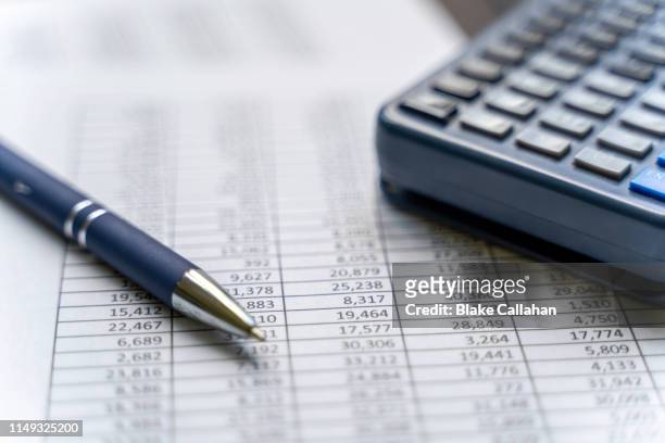 accounting table with pen and calculator - accounting services photos et images de collection