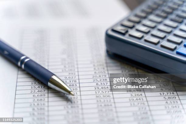 accounting table with pen and calculator - tasse foto e immagini stock