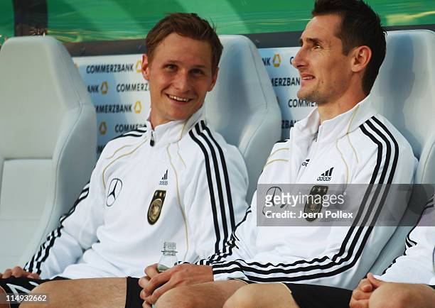 Benedikt Hoewedes and Miroslav Klose of Germany are seen on the bench prior to the international charity match between Germany and Uruguay at...