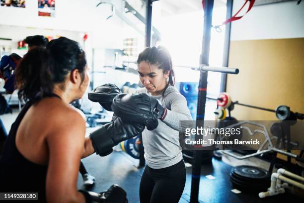 female boxers working out together in boxing gym - mixed boxing fotografías e imágenes de stock