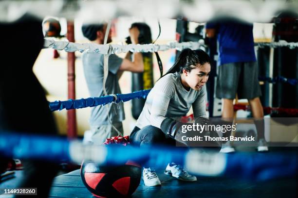 exhausted female boxer resting after workout in boxing gym - female boxer stock pictures, royalty-free photos & images