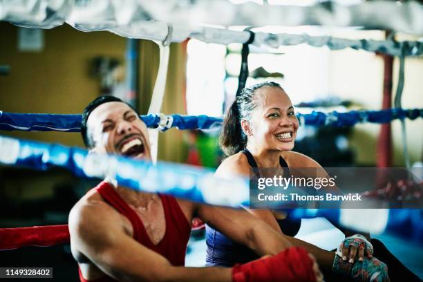 laughing boxers sitting in boxing ring after training session - funny boxing stock-fotos und bilder