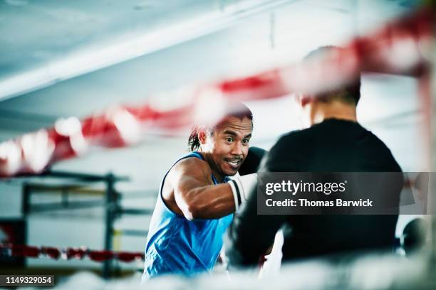 male boxer working out with trainer in boxing ring in gym - filipino boxers stock pictures, royalty-free photos & images