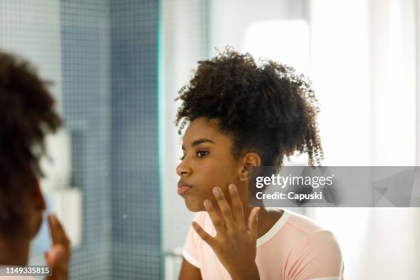 teenage girl looking at herself in the mirror - girl in mirror stock pictures, royalty-free photos & images