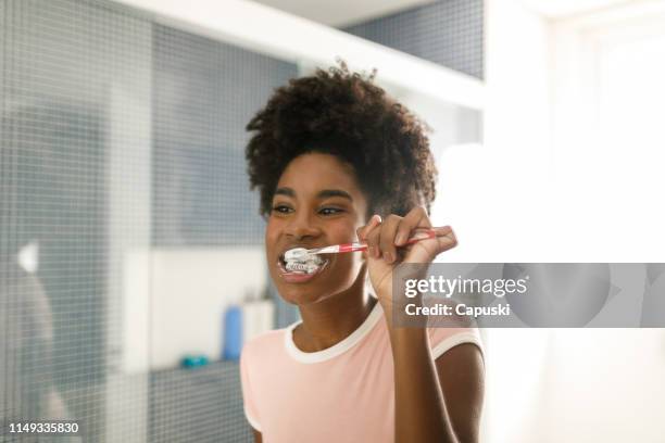 teenage girl brushing her teeth - brushing teeth stock pictures, royalty-free photos & images