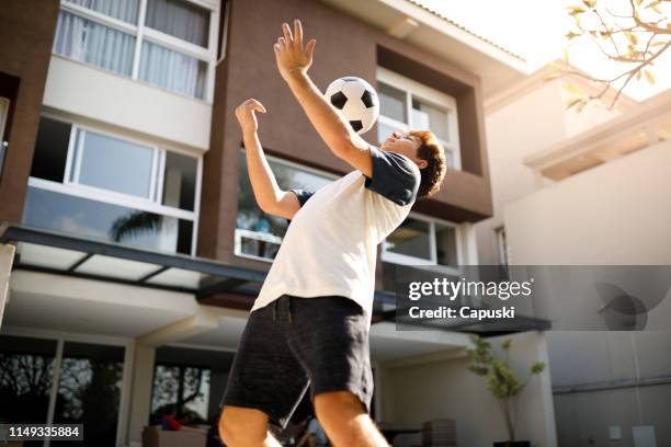 adolescente che fa trucchi di calcio freestyle - chest foto e immagini stock