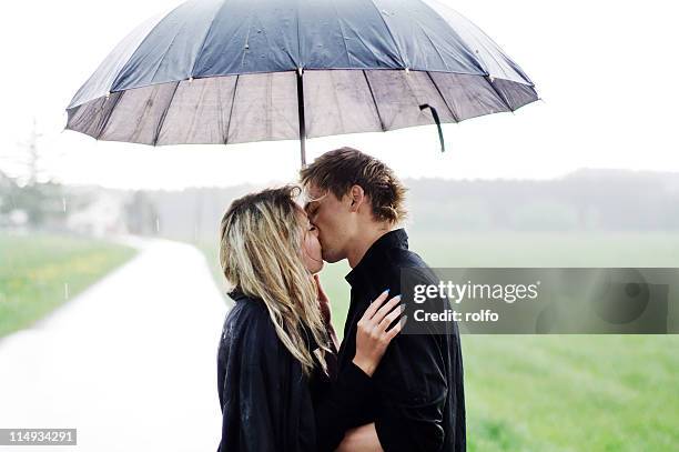 kissing couple - rain kiss stockfoto's en -beelden