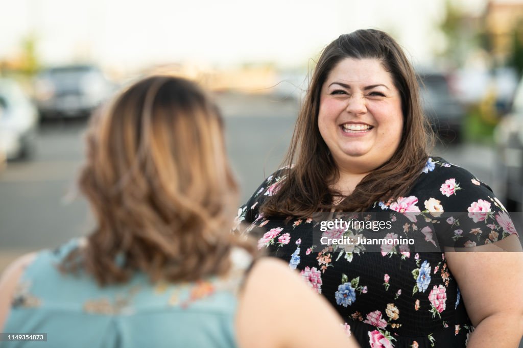 Mujeres adultas medias hablando en medio de la calle