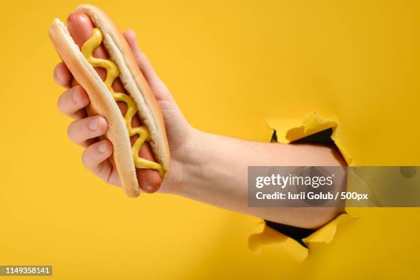 hand taking a hot dog - hot dog - fotografias e filmes do acervo