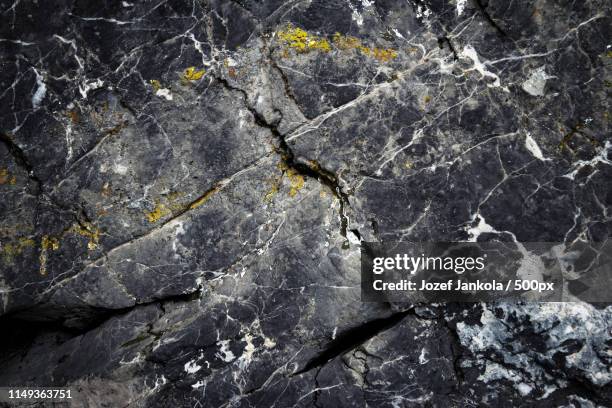 the dark surface of the old limestone rocks - gesteentelaag stockfoto's en -beelden