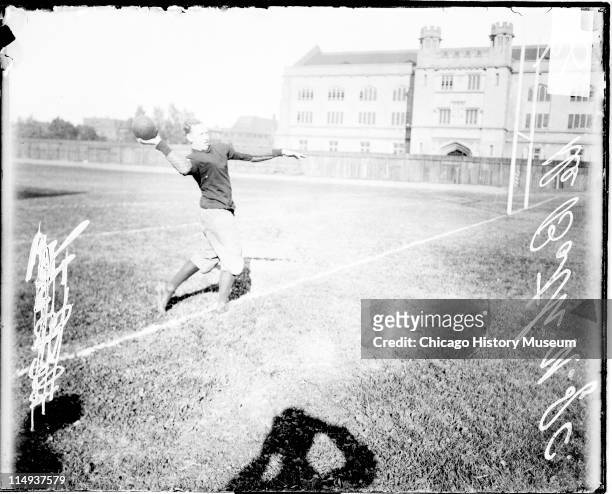 Informal full-length portrait of University of Chicago football player De Both throwing a football, standing on the field at Marshall Field , which...