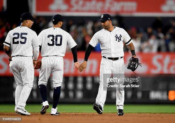 Mike Tauchman of the New York Yankees high-fives teammates Thairo Estrada and Gleyber Torres after the Yankees win 3-1 during game two of a double...