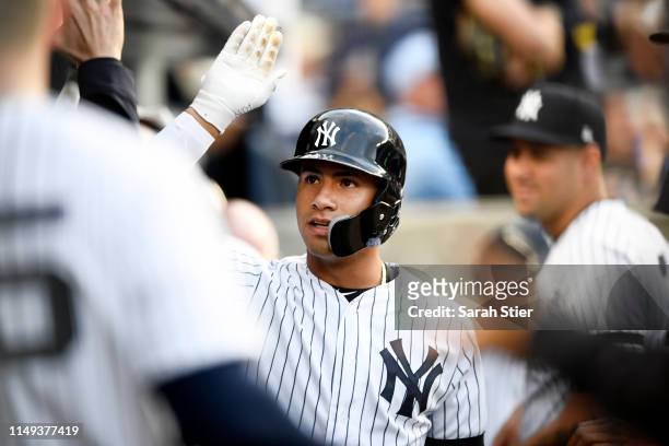 Gleyber Torres of the New York Yankees high-fives his teammates after hitting a home run during the fourth inning of game two of a double header...
